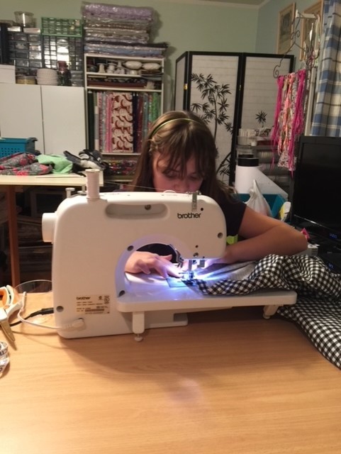 Little Girl Using The Sewing Machine