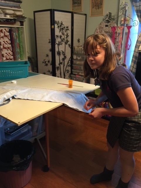 Girl Putting Sewing Pin to Fabric